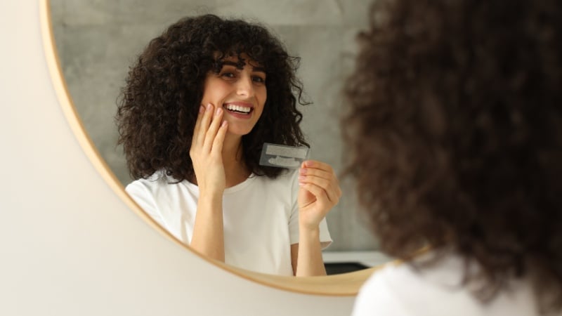 Une femme qui regarde les résultats de son blanchiment dentaire