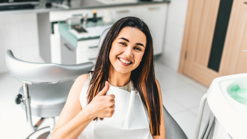 Une femme qui vient de recevoir des soins dentaires apaisants