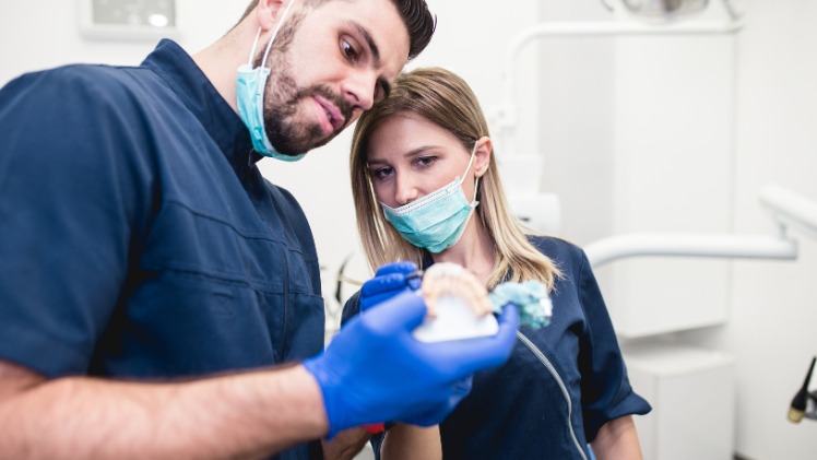 Un dentiste qui fabrique la prothèse dentaire d'un patient