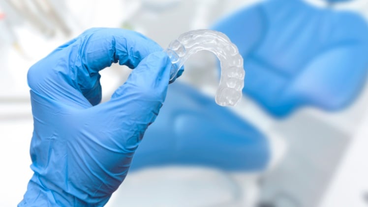 Un dentiste qui tient une gouttière pour redresser les dents