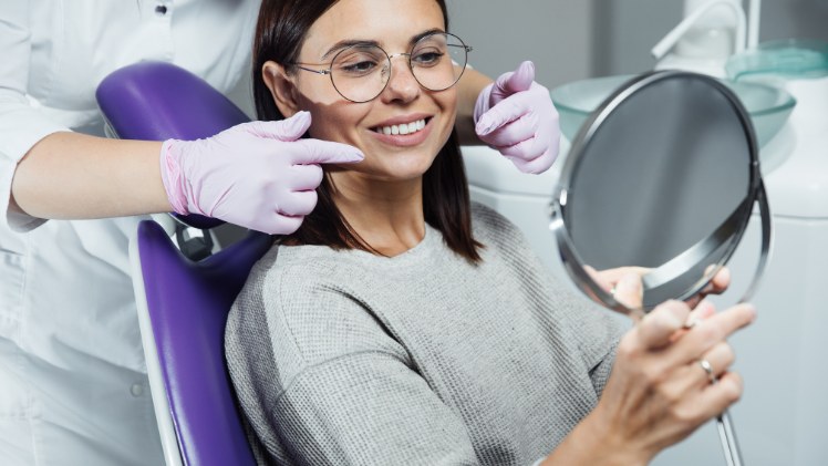 Une femme qui voit son visage rajeunir après un traitement en dentisterie